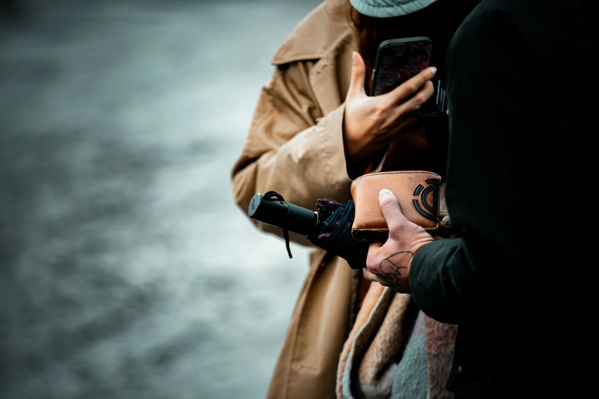 Stock, sostiene una sombrilla doblada | crédito:atelierbyvineeth | https://www.pexels.com/photo/urban-interaction-with-umbrella-and-tattooed-hand-36450830/
