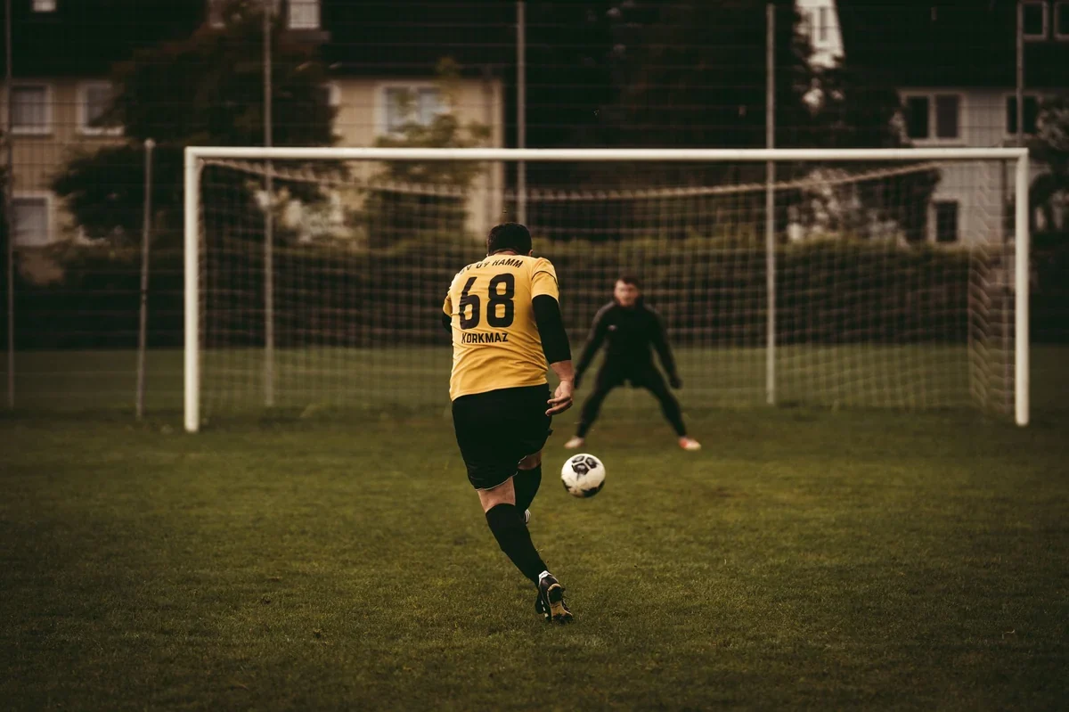 Um jogador de futebol profissional chutando uma bola de futebol
