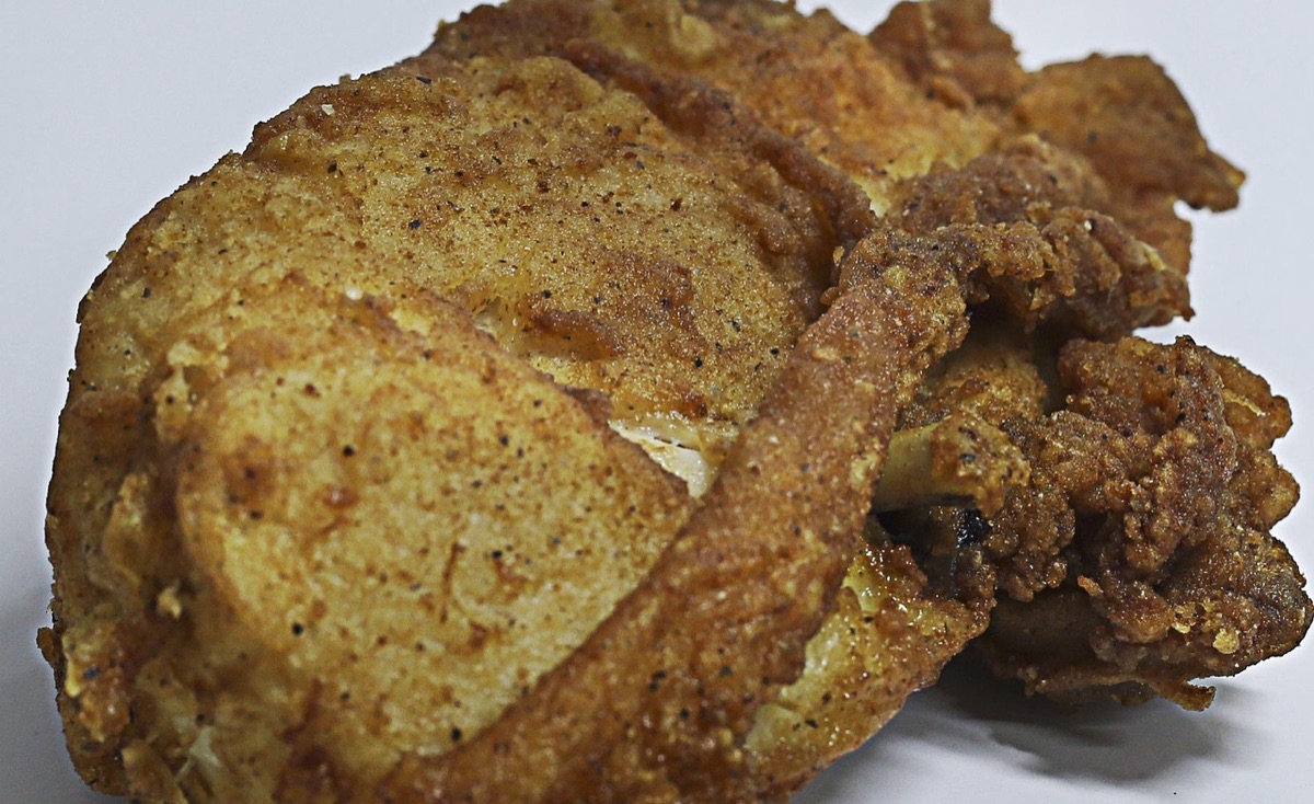 Alimentos crocantes preparados em air fryer, como batatas fritas e asas de frango.