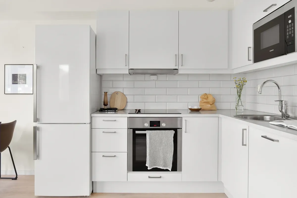 Sleek modern white kitchen featuring stylish appliances and minimalist design. Perfect for contemporary home inspiration.