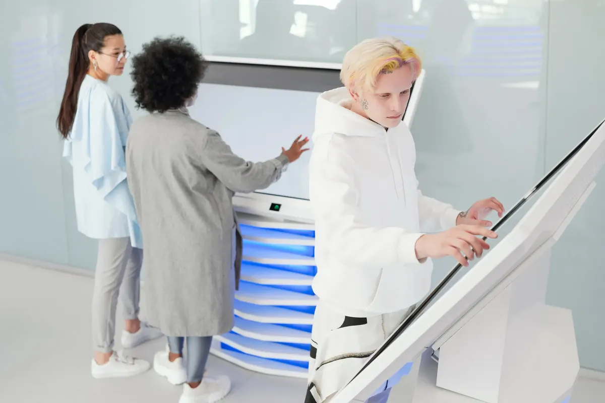 Diverse group interacting with large futuristic touchscreens in a modern tech environment.